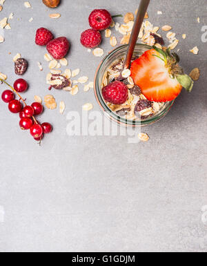 Muesli con fiocchi di avena, frutta secca, noci e frutti di bosco freschi. Muesli in un barattolo di vetro, vista dall'alto. Cibo sano e pulito mangiare conc Foto Stock