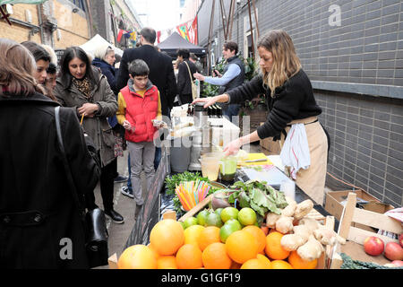 Donna trader juicing al juice stalla sulla strada artigianale DI ROPEWALK Mercato alimentare sotto gli archi ferroviari Maltby Street Bermondsey Londra SE1 KATHY DEWITT Foto Stock
