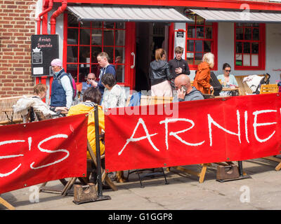 Turisti che si godono una sosta e ristoro presso i tavoli fuori Arnie's Bistro Café in luogo di mercato Whitby North Yorkshire Foto Stock