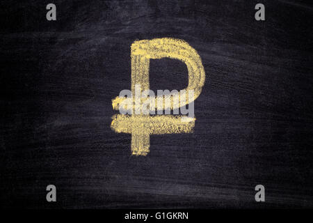 Prelevate il rublo segno sulla lavagna nera dello sfondo. Close up. Foto Stock