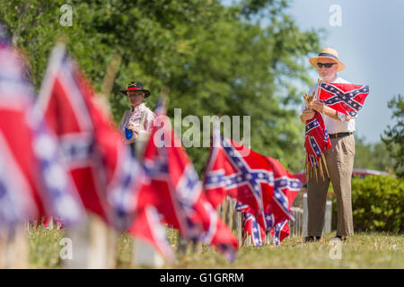 Charleston, STATI UNITI D'AMERICA. 14 Maggio, 2016. Un membro dei Figli della Confederazione rimuove confederato guerra civile bandiere a seguito di un memoriale di servizio marcatura Confederate Memorial Day al Cimitero di magnolia 14 Maggio 2016 a Charleston, Carolina del Sud. La marcatura degli eventi meridionale patrimonio confederato provengono quasi un anno dopo la rimozione del flag confederate dal Capitol dopo l omicidio di nove persone presso la storica madre nera Emanuel AME Chiesa. Credito: Planetpix/Alamy Live News Foto Stock