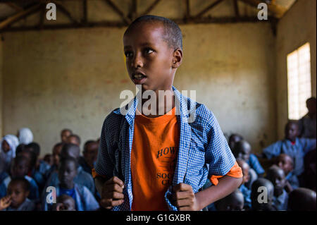 Abdi Rashid (r), un ragazzo di rifugiati dalla Somalia, in piedi di fronte alla scuola primaria di classe dopo essere stato chiamato fuori dall'insegnante presso il campo di rifugiati 1 nel campo di Kakuma, Kenya, 11 maggio 2016. Quattro campi dei profughi dalla Somalia, Sudan Meridionale, Ruanda, Kongo e altri paesi dell'Africa orientale in crisi esiste nel campo di Kakuma. Foto: DOMINIC NAHR/dpa Foto Stock