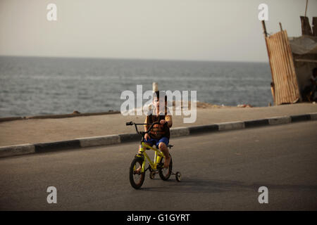 14 maggio 2016 - Gaza City, nella Striscia di Gaza, Territori palestinesi - un ragazzo palestinese cavalca una bicicletta presso la al-Shati Refugee Camp di Gaza City il 14 maggio 2016 (credito Immagine: © Ashraf Amra/APA immagini via ZUMA filo) Foto Stock