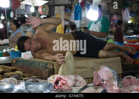 Un uomo sorrisi & onde mentre vi rilassate nel mercato del carbonio situato nel centro di Cebu City, Filippine Foto Stock