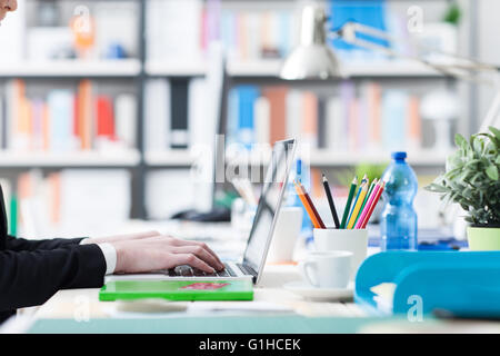 Imprenditrice lavora in ufficio e la digitazione con un laptop, mani vicino fino Foto Stock