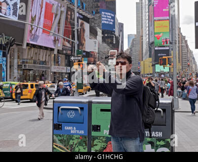 Un turista asiatico prende un selfie in Times Square nel centro cittadino di Manhattan, New York City Foto Stock