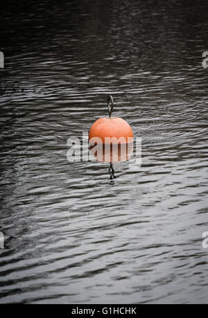 Arancio brillante nautica boa galleggiante su leggermente increspata superficie di acqua Foto Stock