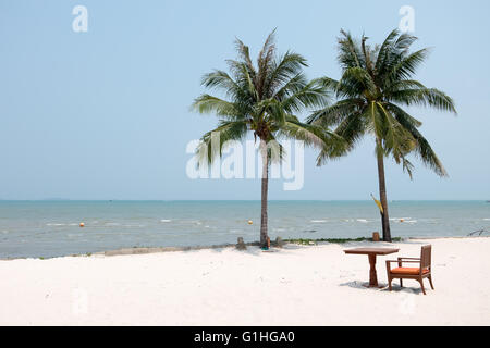 Sedia e tavolo impostata sul bianco sabbia pulita spiaggia con palme da cocco e mare bellissimo. Foto Stock