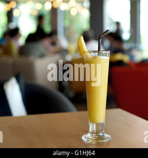 Dolce frullato di mango sul tavolo di legno Foto Stock