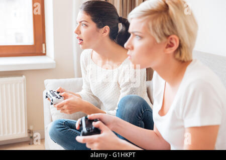 Due amiche per giocare con i videogiochi con joystick Foto Stock