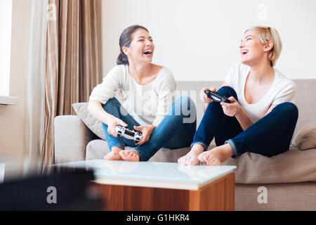 Due amiche ridere i video-giochi con joystick Foto Stock