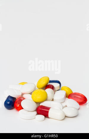 Un mucchio di differenti, varia e colorata pillole, compresse e la droga su un isolato sfondo bianco. orientamento verticale. Foto Stock