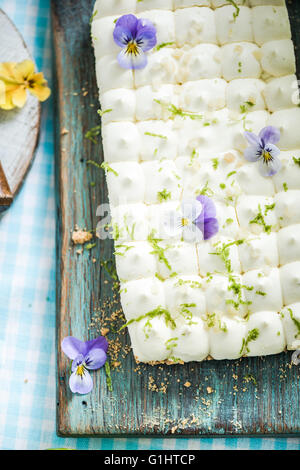 Key Lime pie dal di sopra, decorato con fiori commestibili Foto Stock