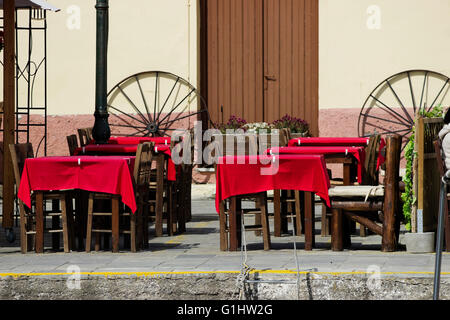 Primo piano della " Veneto " taverna di pesce ristorante vuoto tovaglia rosso coperti tavoli & decorazione in Mirina's Quay. Lemnos Foto Stock