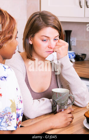 Triste giovane donna di essere confortati da amici Foto Stock