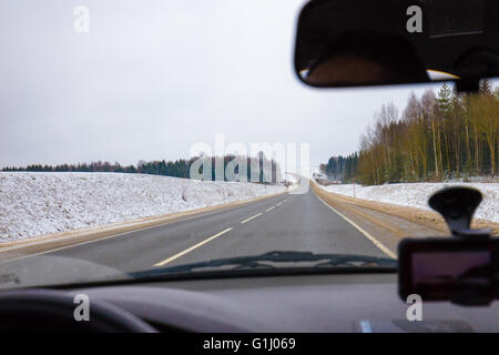 La guida di una vettura sulla strada asfaltata in inverno Foto Stock