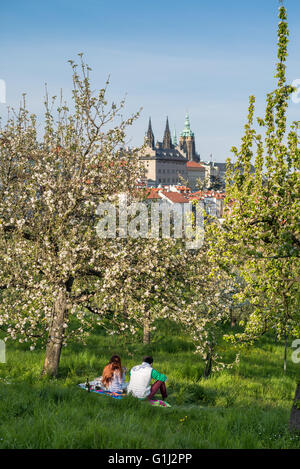 Godendo del sole in primavera, quartiere Lesser di Praga, Repubblica Ceca. Lo sfondo è il Castello di Praga Foto Stock