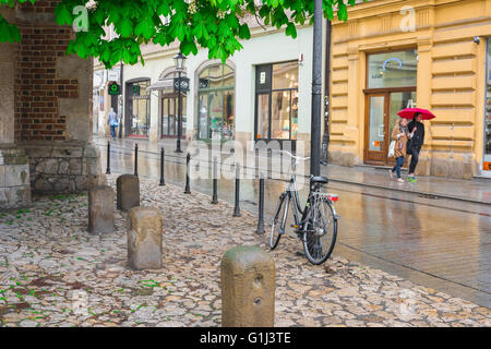 Grodzka Street Cracovia, vista delle donne che camminano attraverso una doccia di aprile in Grodzka Street nella zona della città vecchia di Cracovia, Polonia. Foto Stock