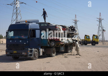 Caricamento rottami di automobili su di un camion nel deserto Foto Stock