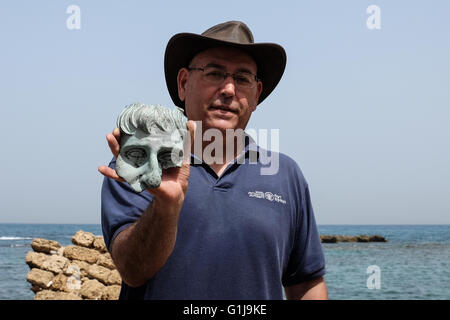 Cesarea, Israele. 16 Maggio, 2016. Giacobbe SHARVIT, Direttore dell'archeologia marina unità dell'Autorità di Antichità Israele, contiene fino ad un frammento di una vita-dimensioni testa di una statua non identificato. Un sottomarino di recuperare indagine condotta nelle ultime settimane presso l'antico porto di Cesarea da subacquei dalle Autorità di Antichità Israele ha portato alla esposizione di una "grande e spettacolare e bellissima e antica marina" del carico di una nave mercantile che affondò durante il periodo tardo romano. Credito: Nir Alon/Alamy Live News Foto Stock