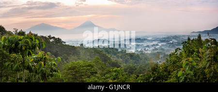 Tramonto su una valle con il Borobudur Ttemple nella distanza, panoramatic vista dalla collina, Java, Indonesia Foto Stock