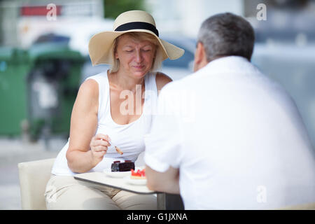 Coppia di anziani di mangiare in outdoor cafe Foto Stock