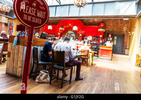 Si prega di attendere di essere seduti accedi Nico ristorante all'interno delle persone mangiare Stamford Town Lincolnshire UK Inghilterra Foto Stock