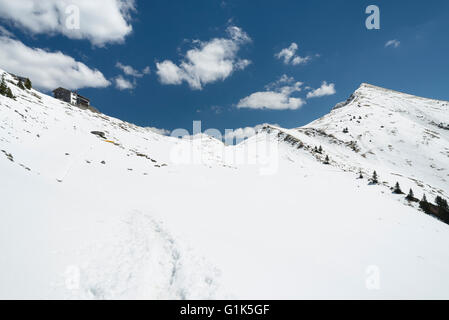 Toelzer il rifugio alpino a snow-capped Delpsjoch sella in montagne Karwendel soleggiata con cielo blu e nuvole bianche,Tirol Foto Stock