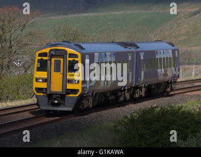 Rampa settentrionale Sprinter 158 Treno in avvicinamento Ribblehead stazione con un servizio per Leeds in sole primaverile Foto Stock