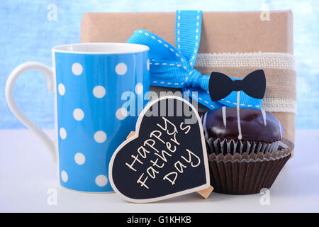 Felice giorno padri cupcake dono in blu pallido e bianco sullo sfondo di legno. Foto Stock