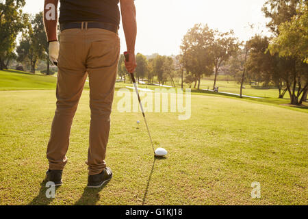 Chiusura del golfista maschio allineando il tee-shot sul campo da Golf Foto Stock