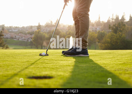Chiusura del golfista maschio allineando il Putt su verde Foto Stock