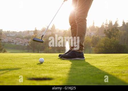 Chiusura del golfista maschio mettendo su verde Foto Stock