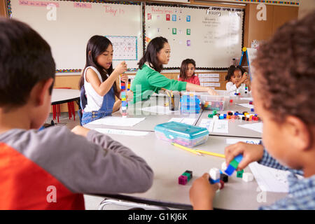 Insegnante di scuola elementare utilizza blocco gioco in classe con i bambini Foto Stock