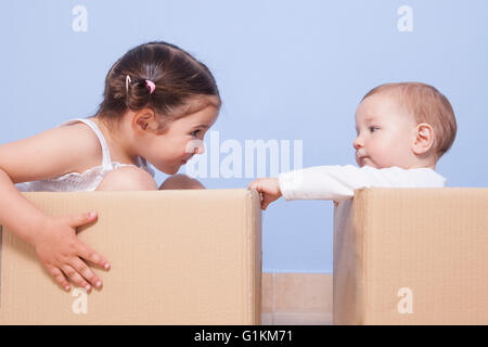 Baby fratello e sorella toddler giocando in scatole di cartone Foto Stock