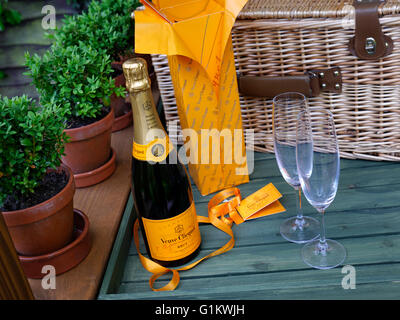 Veuve Clicquot Brut Champagne di lusso e i bicchieri sul fresco giardino Tavolo picnic con ostacolare in vimini Foto Stock