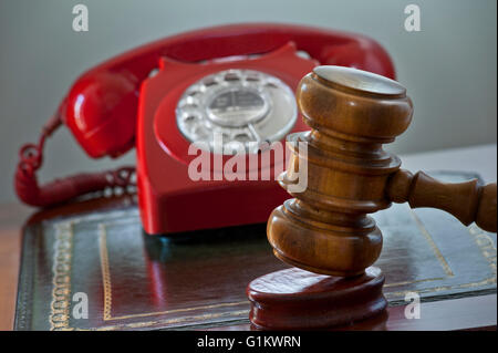 Tradizionale casa d'aste concetto con retro red hot line telefonica offerte e i banditori martello martello sul podio auction scrivania Foto Stock