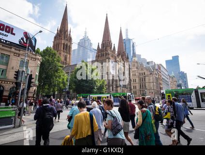 Le persone che attraversano la Flinders Street vicino alla Cattedrale di San Paolo a Melbourne, Australia Foto Stock