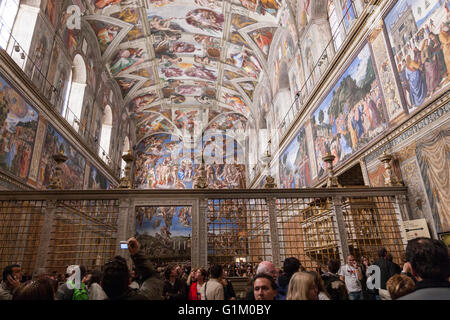 Overcrowd con tourist nella Cappella Sistina, soffitto dipinto da Michelangelo, dalla parete di ingresso Foto Stock