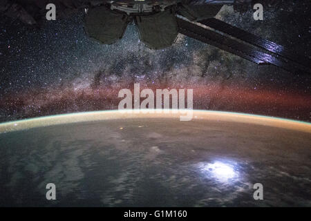 Ancora immagine presa da un lasso di tempo sequenza di stelle nella Via Lattea visibile su un lembo di terra come si vede dalla spedizione 44 equipaggio a bordo della Stazione Spaziale Internazionale il 9 agosto 2015. Astronauta Kjell Lindgren catturato un fulmine dalla terra così luminosa che si accende la stazione spaziale pannelli solari. Foto Stock