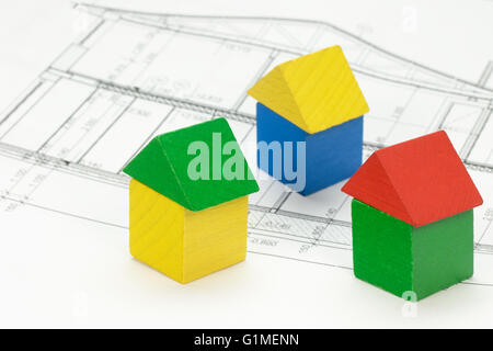 Tre case di legno forme multicolori sono in piedi sul piano della casa. Foto Stock