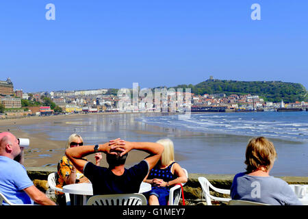 SCARBOROUGH, nello Yorkshire, Regno Unito. Maggio 09, 2016. I clienti a rilassarsi presso l'orologio cafe con la vista del South Beach a Scarborough. Foto Stock