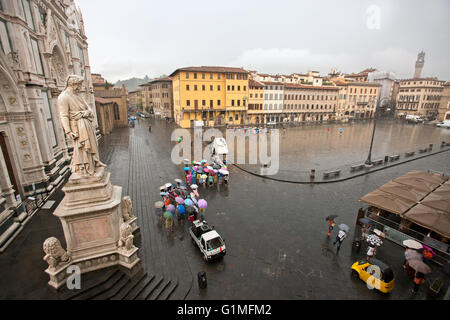 Basilica di Santa Croce con la statua di Dante a Firenze, Italia pioggia e turistico in piazza Foto Stock