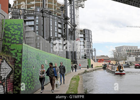 La gente camminare passato barca sul Regents Canal alzaia vicino Gasholders Appartamenti in Kings Cross Londra UK KATHY DEWITT Foto Stock