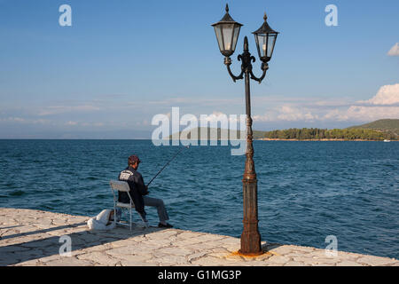 Un pescatore sulla banchina, Vonitsa, Amvrakikos Kolpo, Grecia Foto Stock