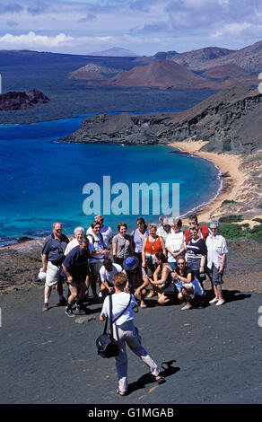 I turisti posano per foto, sopra il pinnacolo di roccia, Bartolomeo Isola, Galapagos, Ecuador, Sud America. Foto Stock