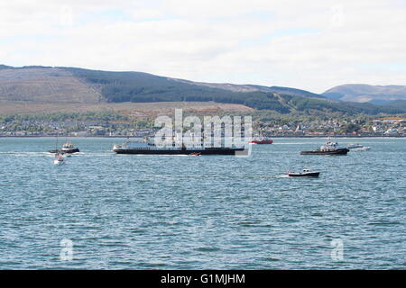 L'arrivo della storica motonave Il TS Queen Mary torna alla Clyde, con un accompagnamento di imbarcazioni di piccole dimensioni di dare il benvenuto a lei. Foto Stock