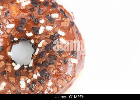 Una grande ciambella con glassa di cioccolato e spruzza mostrando il suo foro isolato su un fondo bianco. Foto Stock