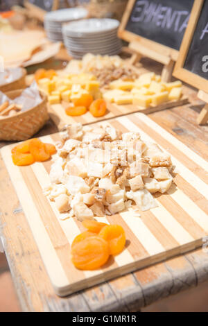 Diversi tipi di formaggio servita con albicocche secche e noci su vintage tavolo in legno Foto Stock