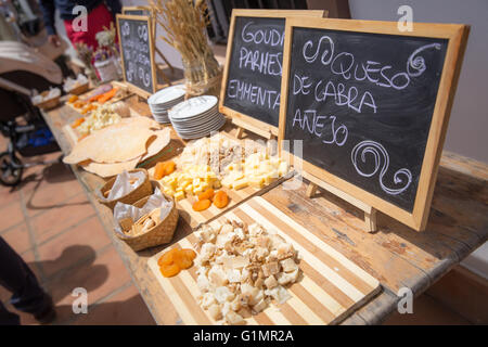 Diversi tipi di formaggio servita su vintage tavolo in legno e lavagne scritto in spagnolo Foto Stock
